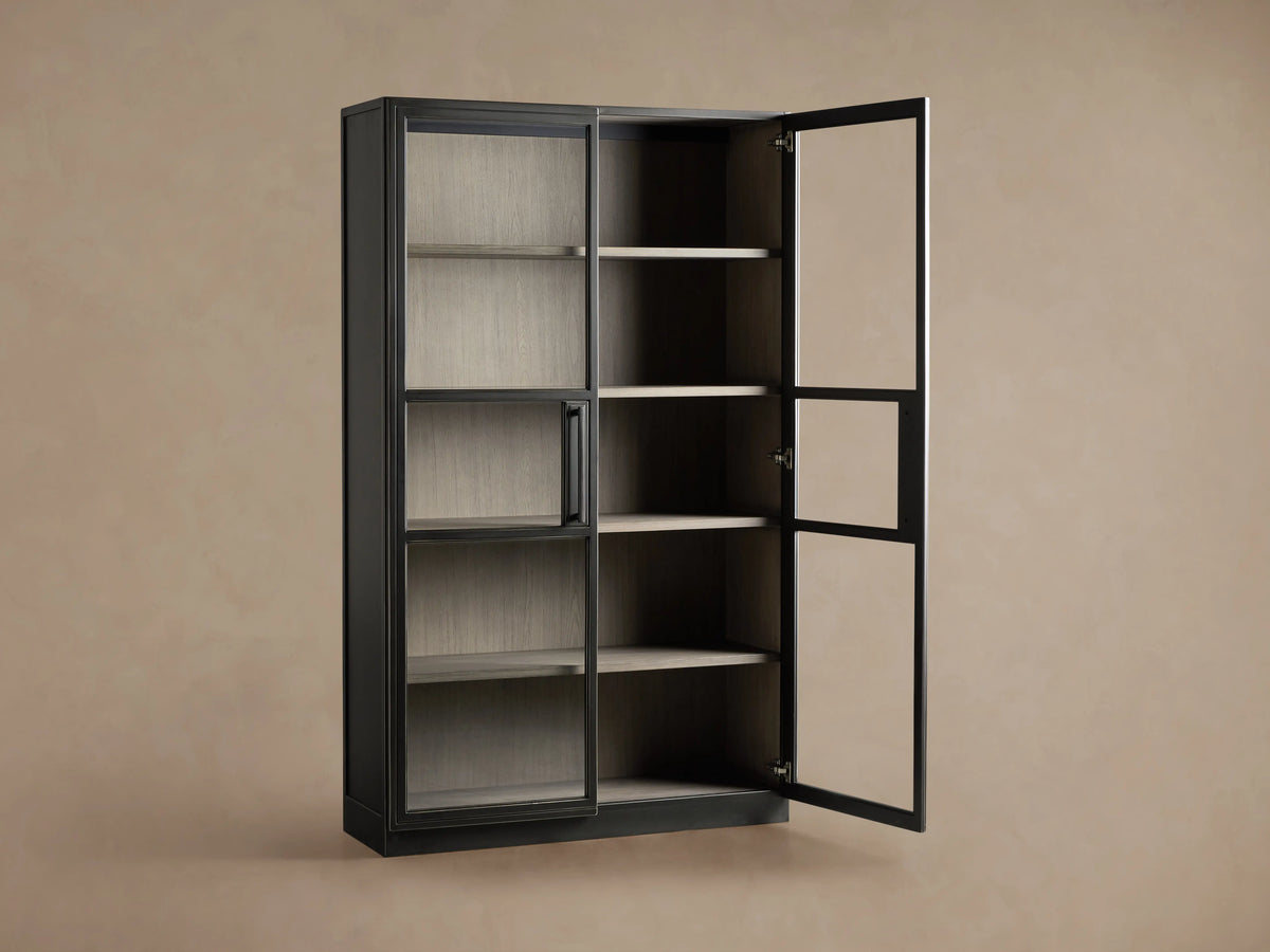 Factory Cabinet with a dark Usine Black finish, displaying tempered glass doors showing visible shelves in a chic grey Stone finish.