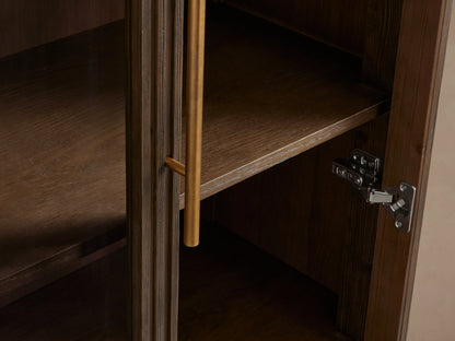 Finnley Glass Cabinet with dark wood finish, two glass doors with brass pulls, four visible shelves, and a brass base.