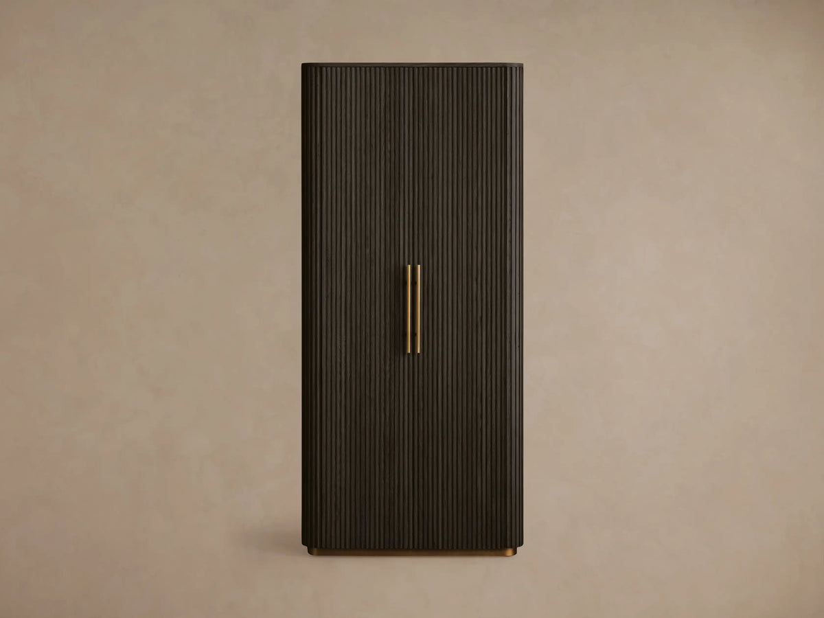 Dark brown Finnley Cabinet with a fluted door partially open, showcasing a brass handle and interior shelves with books.