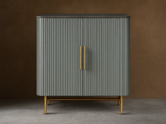 Finnley Bar Cabinet in pumice with vertical reeding detail, dark top, and gold brass-finished handles & legs.