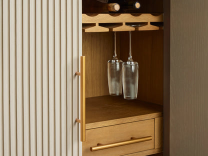 Open Finnley Bar Cabinet with light oak interior shelves, hanging glasses, and bar tools. One drawer is open revealing a cloth. Marble top & brass pulls.