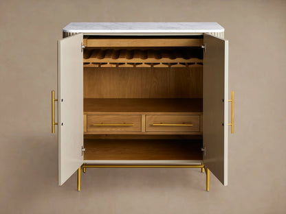 Close-up of open Finnley Bar Cabinet, showing reeded Pumice door, brass handles, hanging wine glasses, wine bottles, and drawer.