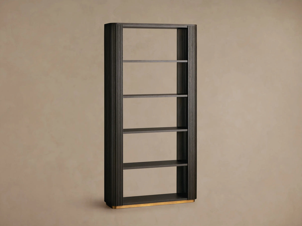 Finnley Bookcase, dark ebony oak veneer, with fluted sides, 5 open shelves displaying a vase, plant, and books, on brass feet.