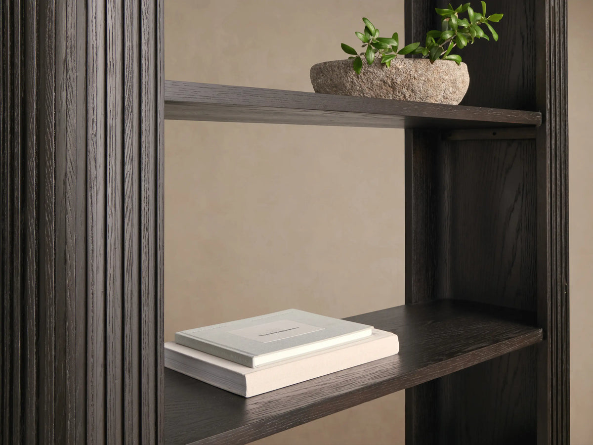 Tall Finnley Bookcase in ebony wood veneer with fluted sides, four fixed shelves, and a brass-finished plinth base.