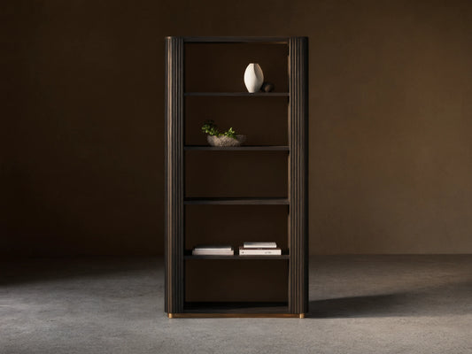 Finnley Bookcase, dark ebony oak veneer, with fluted sides, 5 open shelves displaying a vase, plant, and books, on brass feet.