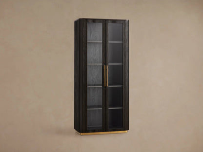 Tall Finnley Glass Cabinet in dark wood with fluted details, two tempered glass doors, brass pulls, and a golden plinth base.