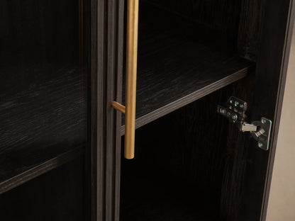 Finnley Glass Cabinet, dark ebony wood with fluted sides, two glass doors with brass pulls, and a brass plinth base.