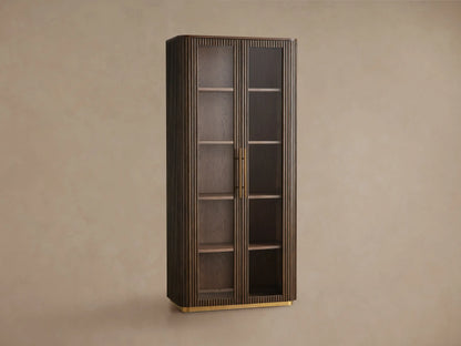 Finnley Glass Cabinet: Tall, dark wood cabinet with rounded corners, two glass doors, brass pulls, fluted sides, shelves, and a brass plinth base.