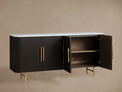 Front view of an Ebony Finnley Sideboard with reeding, a white marble top, and brass-finished handles and legs.