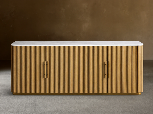 Finnley Plinth Sideboard with honey finish, ribbed white oak wood design, brass hardware, and white marble top against a neutral background.