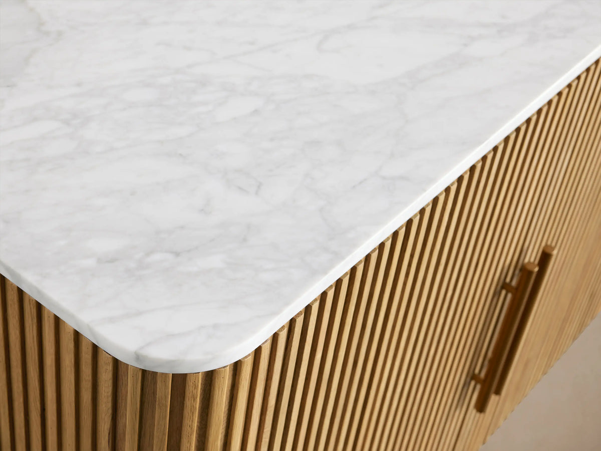 Finnley Plinth Sideboard with open fluted oak veneer cabinet, brass handles, marble top, showing interior shelves with wine glasses.