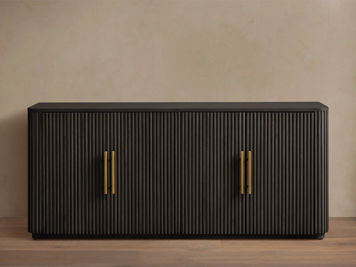 Finnley Wood Sideboard with ebony finish, ribbed surface, and brass-finished handles; set against a neutral background.
