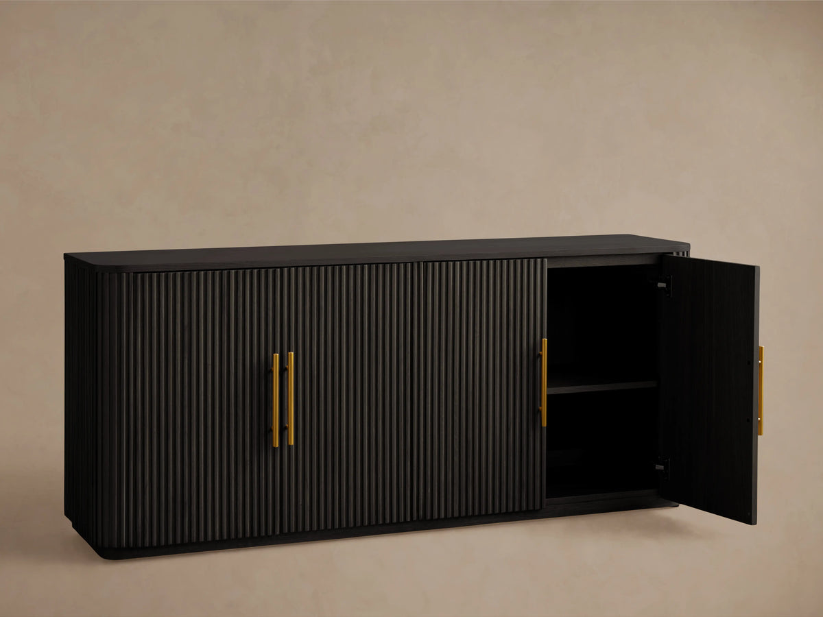 Finnley Wood Sideboard with ebony finish, ribbed surface, and brass-finished handles; set against a neutral background.