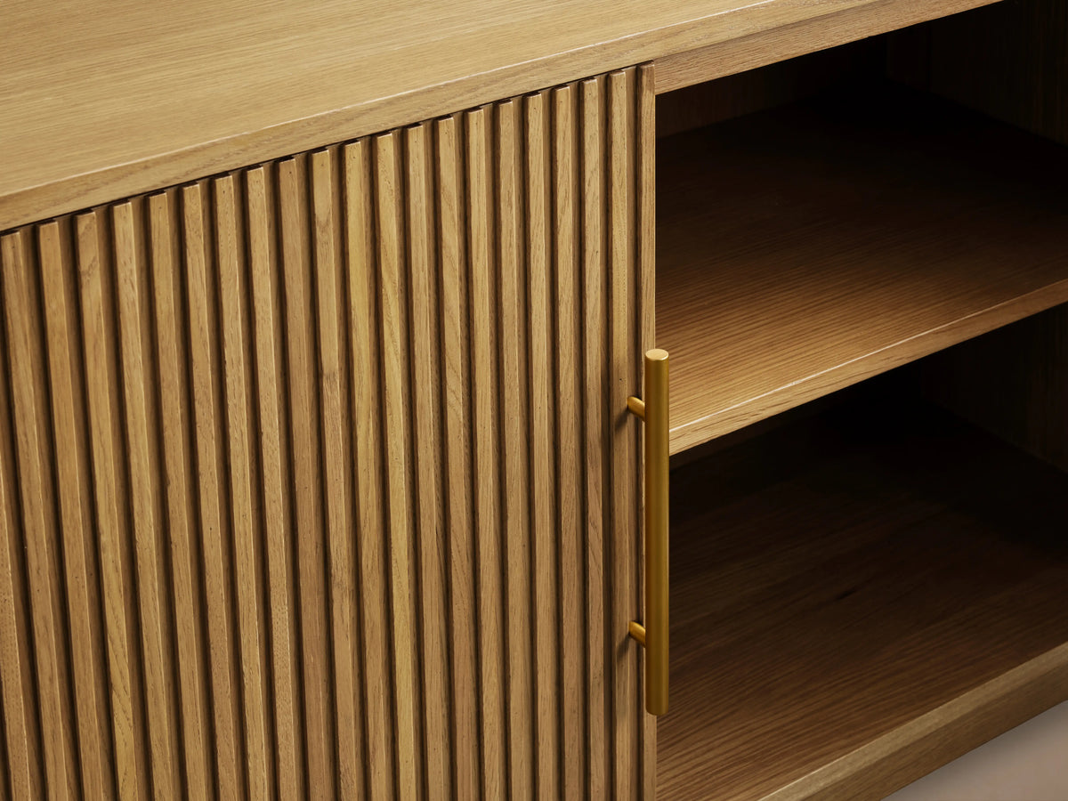 Finnley Wood Media Console in Honey finish with vertical slatted design, open door showing shelves, and brass hardware.