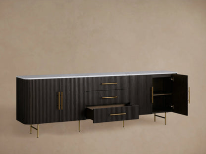 Ebony-finished Finnley Sideboard with a white marble top, three center drawers, and fluted cabinet doors with brass-finished handles.