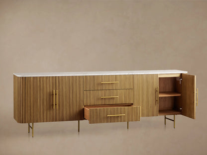 Finnley Sideboard with honey finish, featuring vertical slats, three centered drawers, two side cabinet doors, and a white marble top.