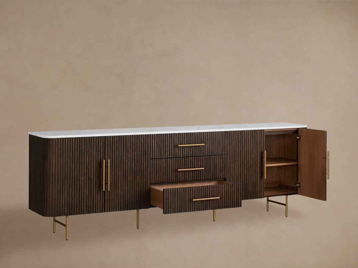 Finnley Sideboard with a rich dark wood finish, three central drawers, two cabinet doors, brass handles, and slim legs.