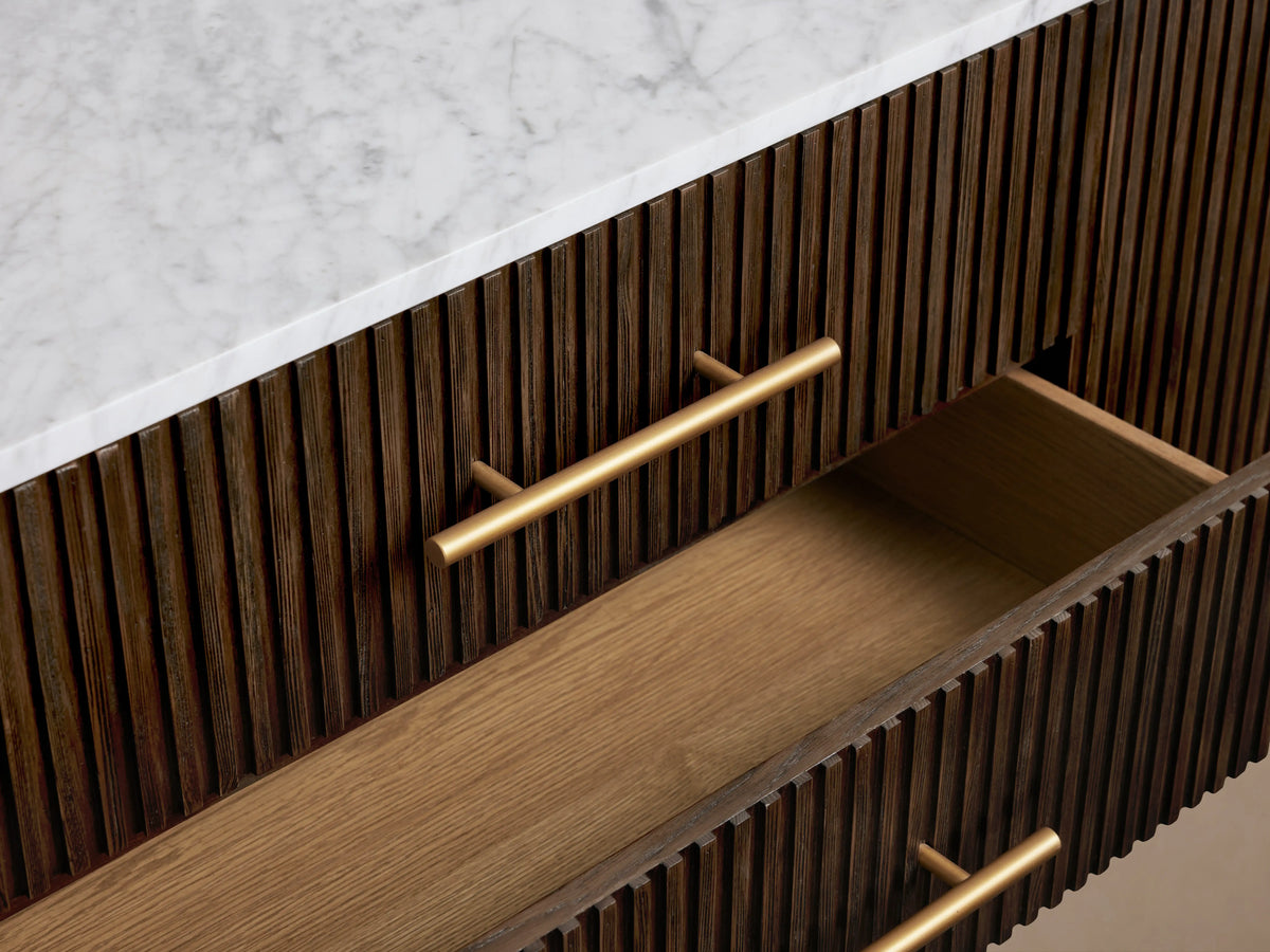 Finnley Sideboard in dark wood with brass-finished handles, three drawers slightly open, two doors exposing shelves, on slender legs.