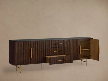 Finnley Sideboard with Honey finish, dark wood grain texture, three central drawers, two doors, brass-finish handles, on slender legs.