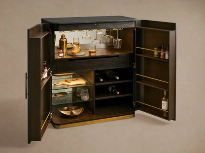 Finnley Plinth Bar Cabinet, dark ebony wood with fluted doors, brass handles, bluestone top, and brass plinth base.