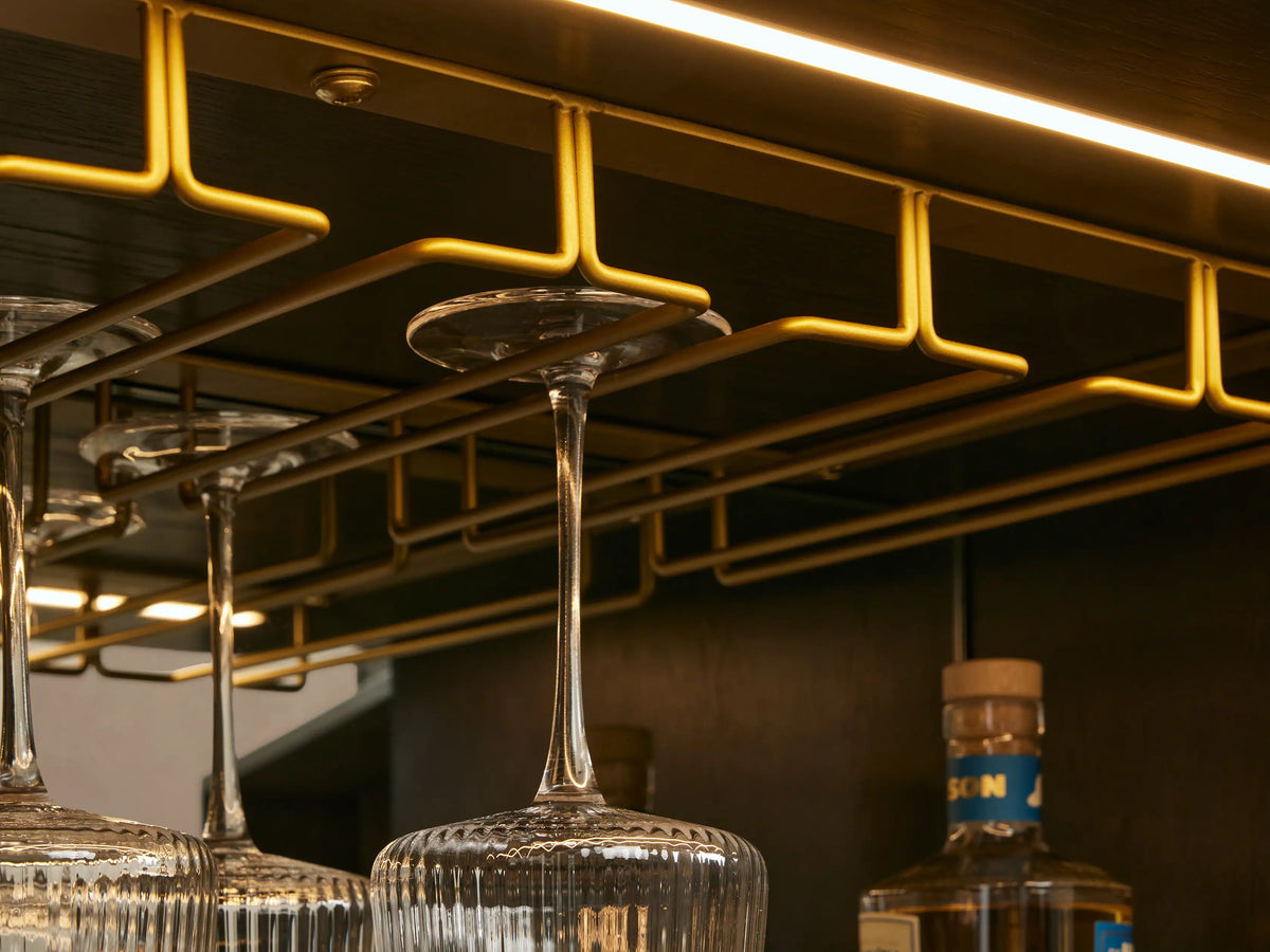 Close-up of dark ebony Finnley Bar Cabinet, open drawer, wine storage, mirrored shelf with drink, persimmons, & glasses.