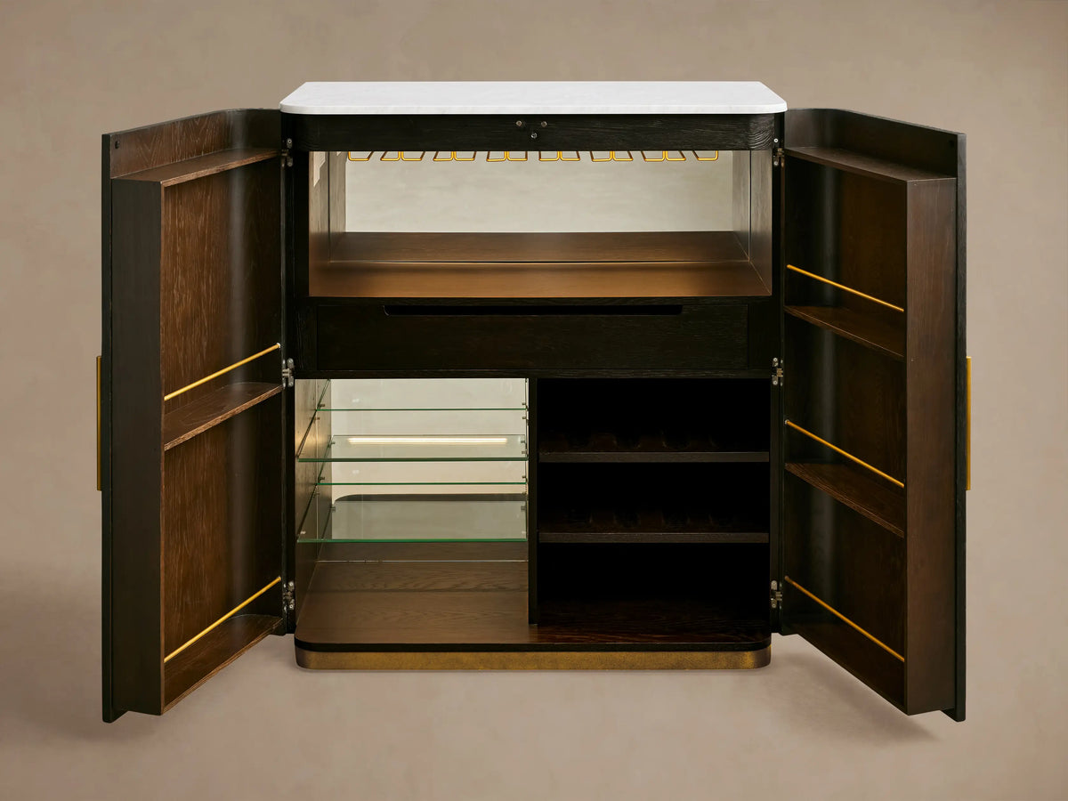 Close-up of Finnley Plinth Bar Cabinet interior: brass stemware rack holds clear wine glasses under a bright LED light strip.
