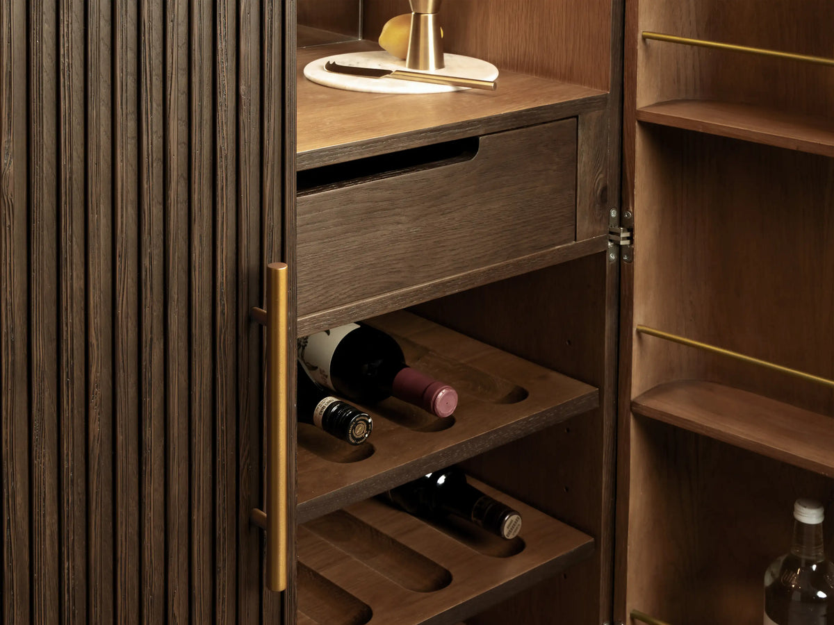 Mocha Finnley Plinth Bar Cabinet interior open, white marble top, mirrored back, barware, pulled drawer, wine & bottle storage.