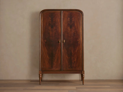 Frances Cabinet: Dark mahogany cabinet with book-matched figured veneer, rounded top, brass handles, turned legs, on a wood floor.