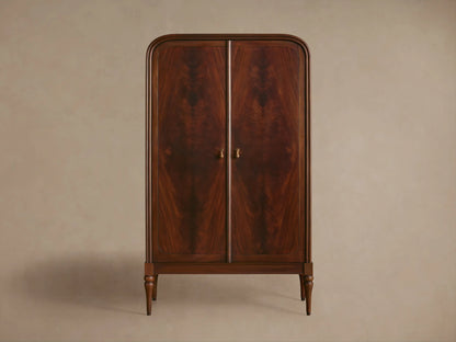 Frances Cabinet: Dark mahogany with unique figured grain. Rounded top, one door open showing shelves and decorative items. Brass knob.