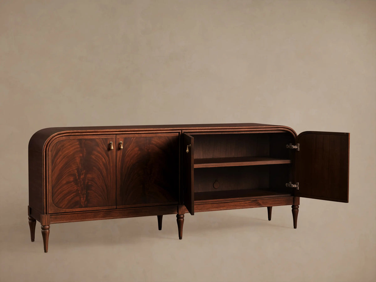 Frances Sideboard, dark mahogany with book-matched flame veneer on 4 doors, brass pulls, rounded corners, tapered legs.