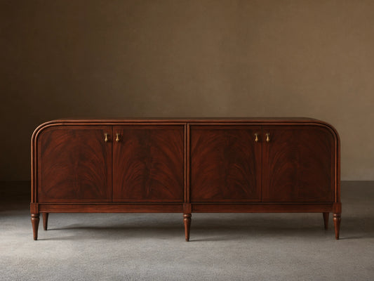 Frances Sideboard, dark mahogany with book-matched flame veneer on 4 doors, brass pulls, rounded corners, tapered legs.