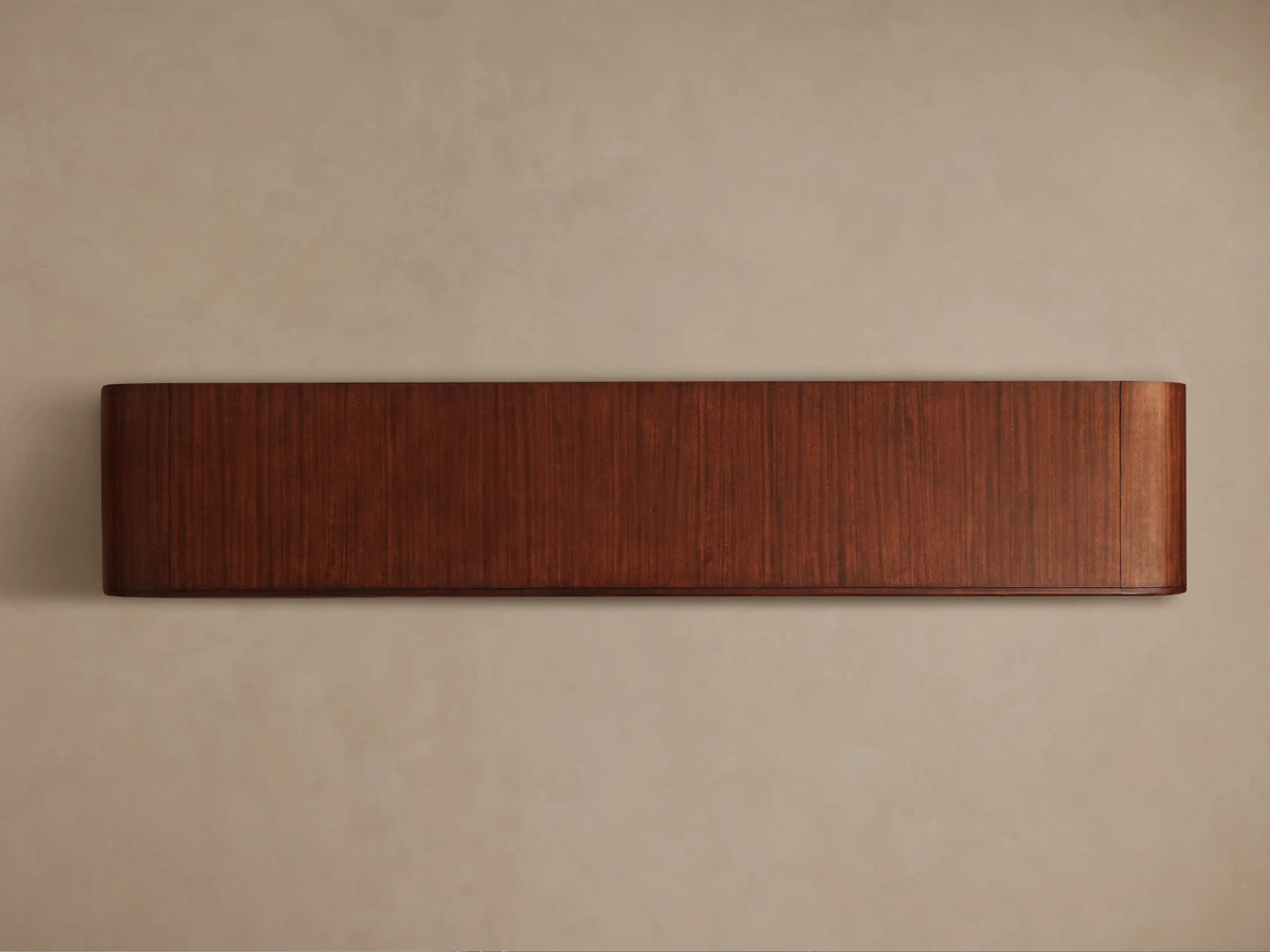 Front view of the Frances Sideboard with Drawers, a long, horizontal piece of reddish-brown wood with vertical grain and rounded ends.