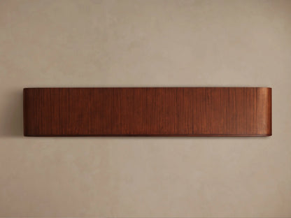 Front view of the Frances Sideboard with Drawers, a long, horizontal piece of reddish-brown wood with vertical grain and rounded ends.