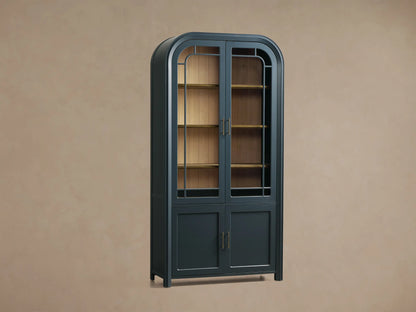 Close-up of the dark blue Gatlin Glass Cabinet, showing wooden shelves, antique brass rails, and glass paneled doors with decor inside.