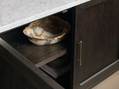 Close-up of the mocha Gatlin Hutch, showing a partially open cabinet with a white honed Carrara marble top and a stone bowl on a shelf.