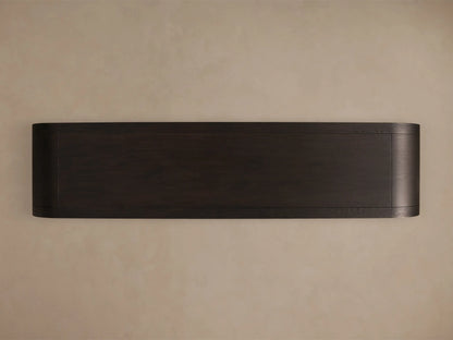 Close-up of the dark wood Gatlin Sideboard, featuring a rounded corner, glass door with a brass pull, and light wood interior shelves.