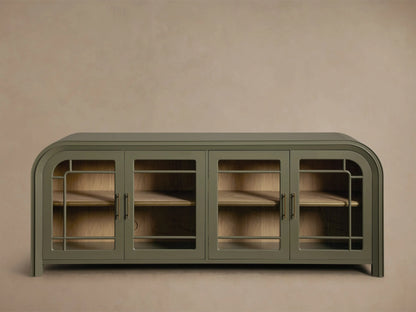 Close-up of the Olive Green Gatlin Sideboard with rounded corners, open glass door revealing wooden shelves, dark glasses, and brass pull.