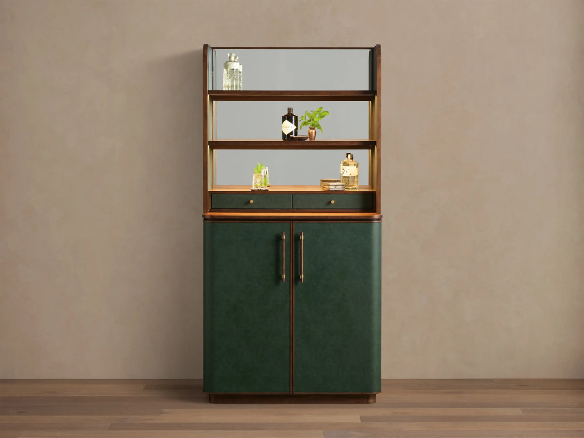 Front view of the Forest Green Grant Bar Cabinet, with dark green upholstered lower doors, brass pulls, wood accents, and mirrored shelves.