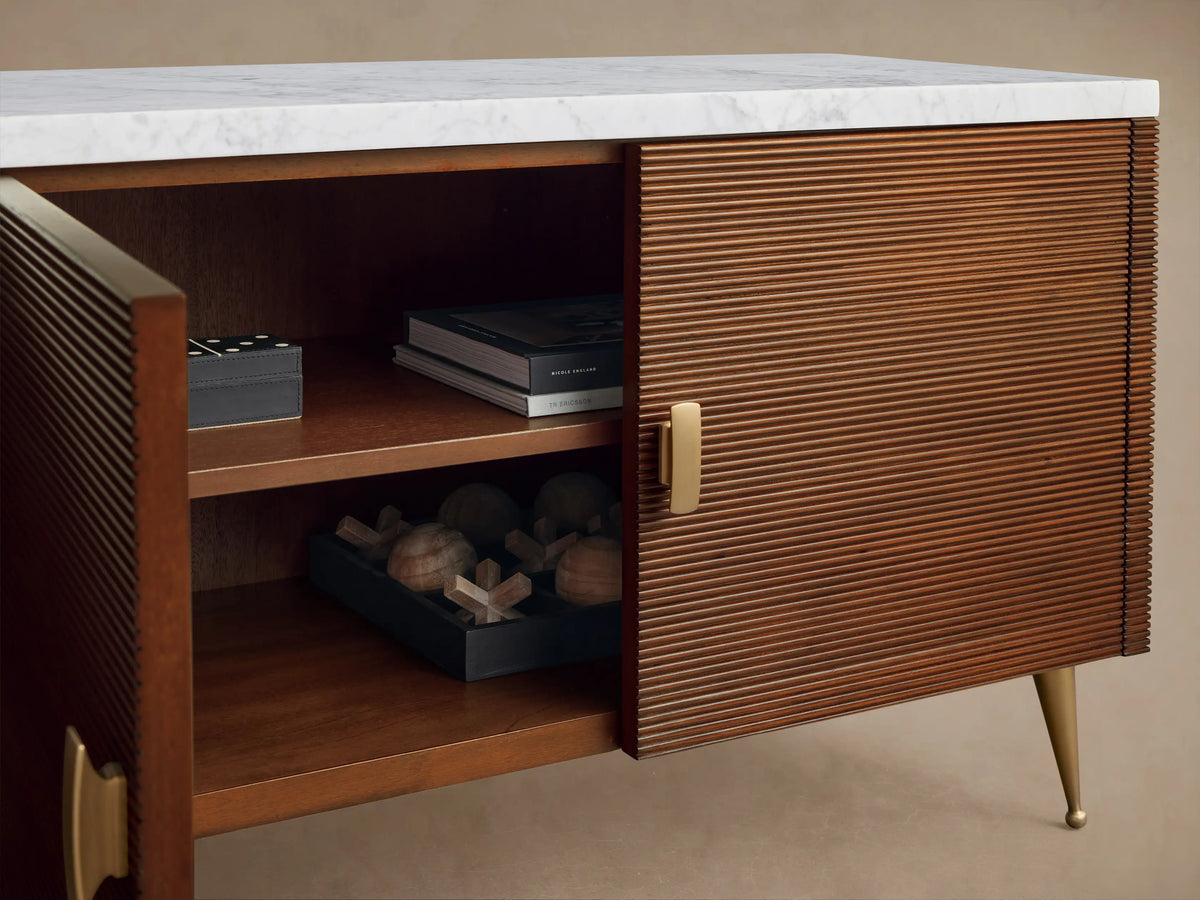 Giselle Media Console, rich brown mahogany, white marble top, horizontal reeded doors, brass handles. Right door open revealing shelves.