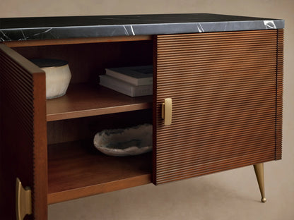 Giselle Media Console: dark mahogany wood with reeded doors & black marble top. Brass handles. Right doors open, revealing interior shelves.