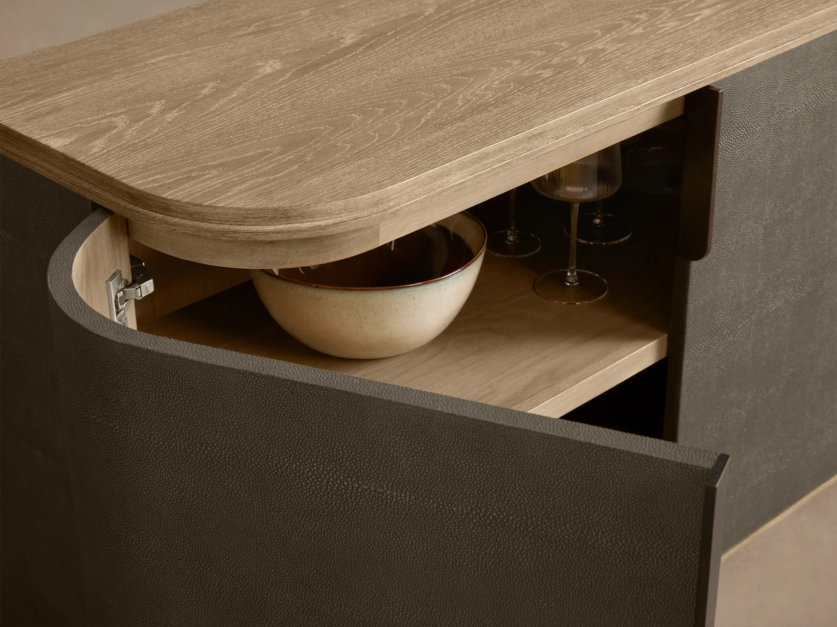 Harrow Media Console: Dark gray faux shagreen console with rounded edges, light wood top, and four doors with thin dark handles.