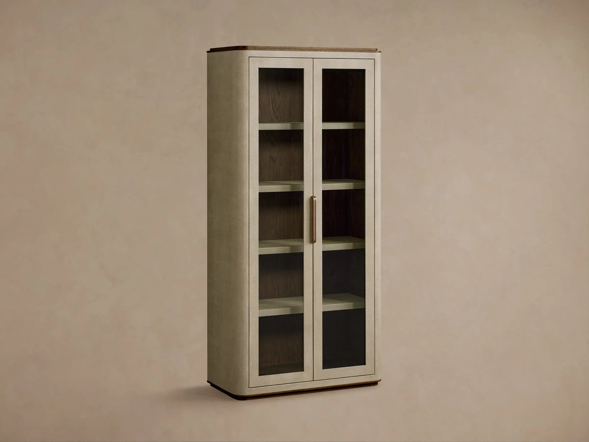 Close-up of Harrow Cabinet interior, showing beige faux shagreen shelves, oak wood back, bronze handle, marble box, & ceramic items.