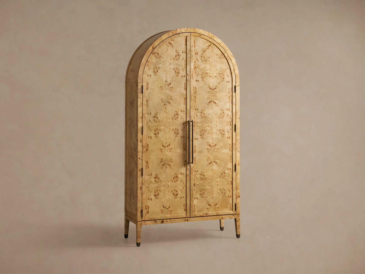 Open Hattie Burl Cabinet in light oak finish, displaying five shelves with decor items. Arched top, exposed hinges, reeded hardware.