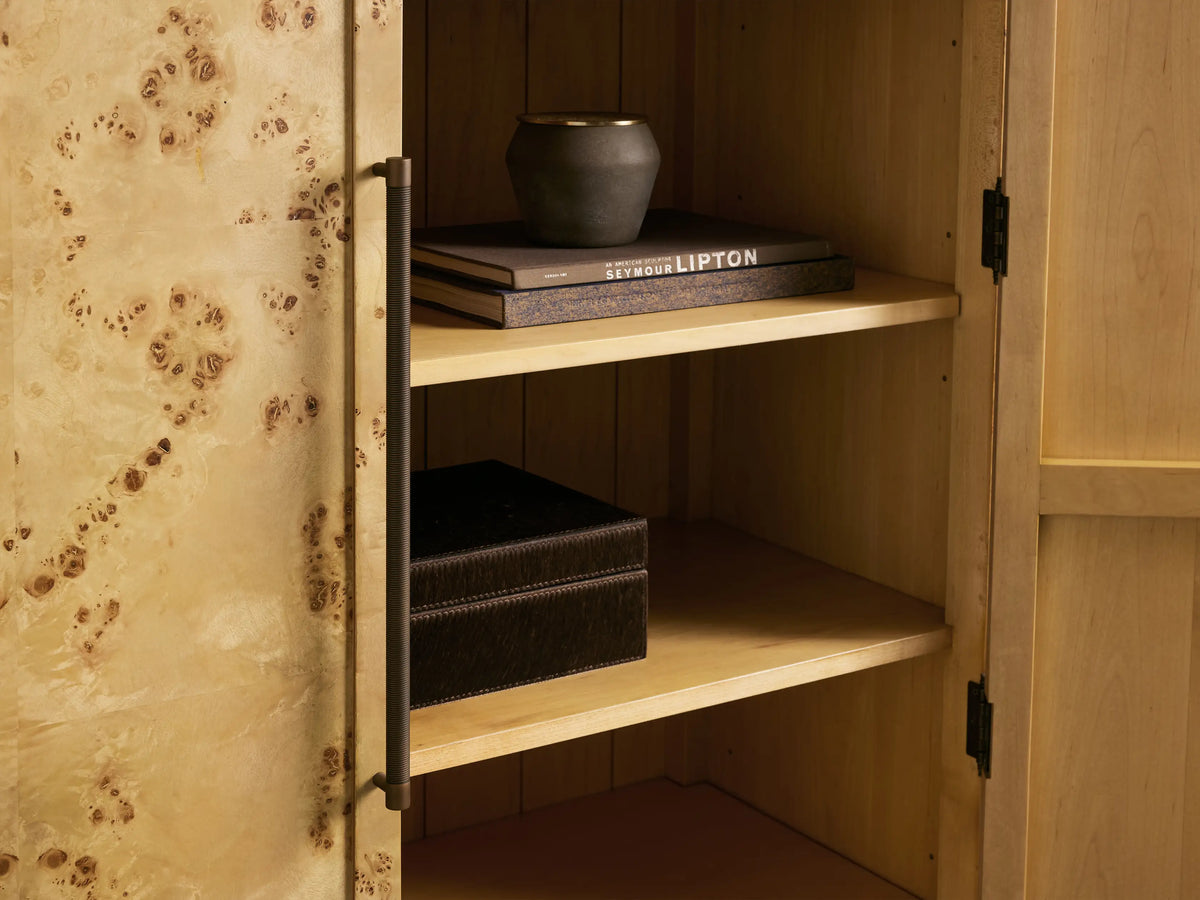 Hattie Burl Cabinet with an arched top and wood finish, featuring swirling burl designs. Two doors with antique reeded hardware, brass-capped feet.