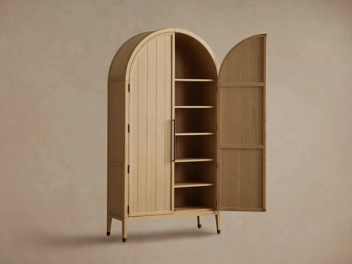 Hattie Cabinet interior showing two wooden shelves with books and a decorative bowl. The cabinet has oak finish and visible hinges.