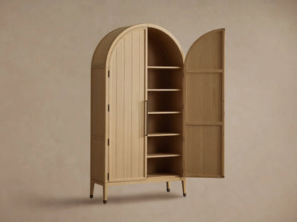 Hattie Cabinet interior showing two wooden shelves with books and a decorative bowl. The cabinet has oak finish and visible hinges.