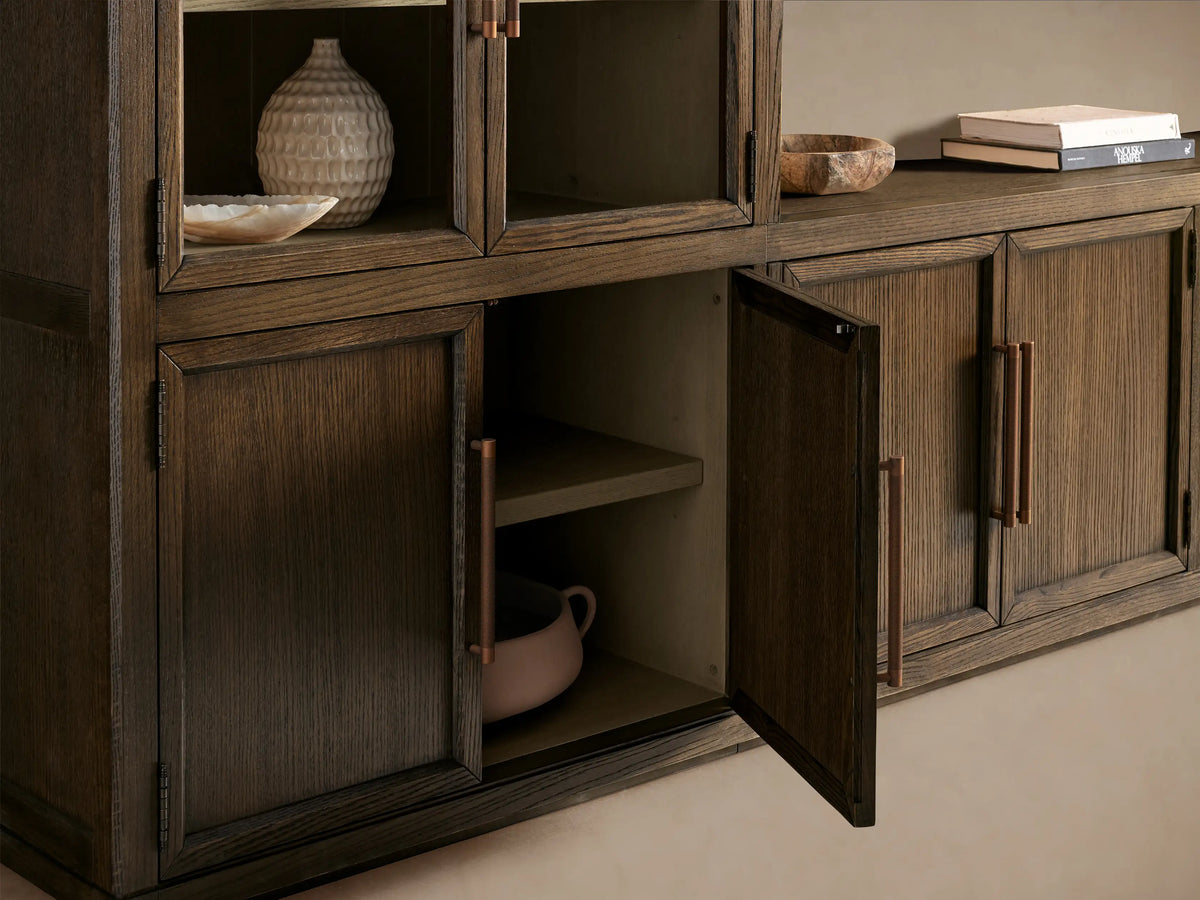 Hattie Glass Media Cabinet. Dark oak system: 2 tall units w/ arched glass doors, light shelves, & central low unit. Bronze handles.