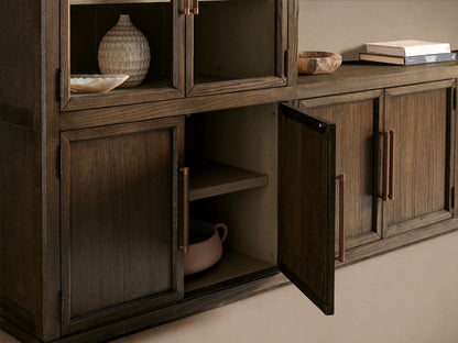 Hattie Glass Media Cabinet. Dark oak system: 2 tall units w/ arched glass doors, light shelves, & central low unit. Bronze handles.