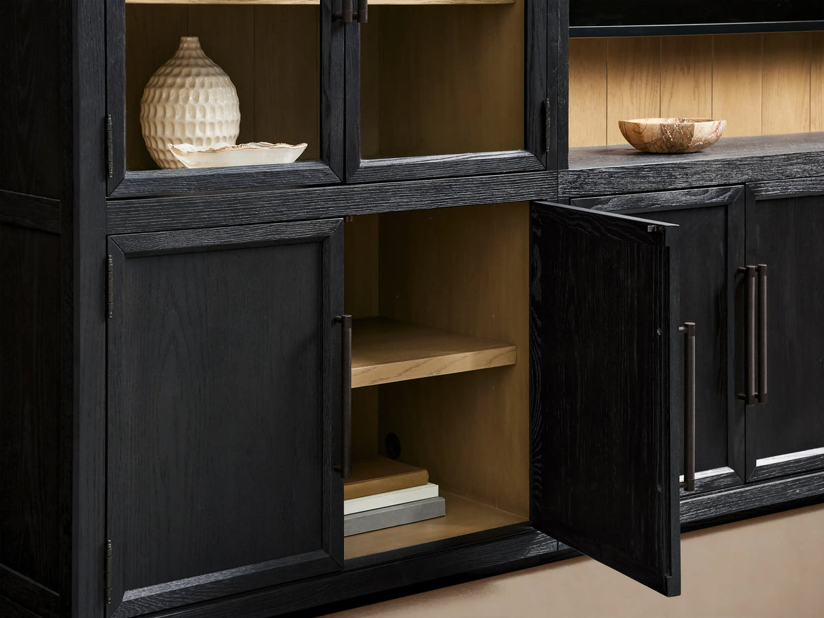 Front view of the black oak Hattie Wall Unit‚Ñ¢ with light shiplap back paneling behind a black TV and arched glass cabinets.