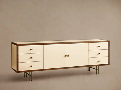 Henton Media Console in a rectangular shape with a wooden frame and cream-colored front. Features two central doors and three drawers on each side.